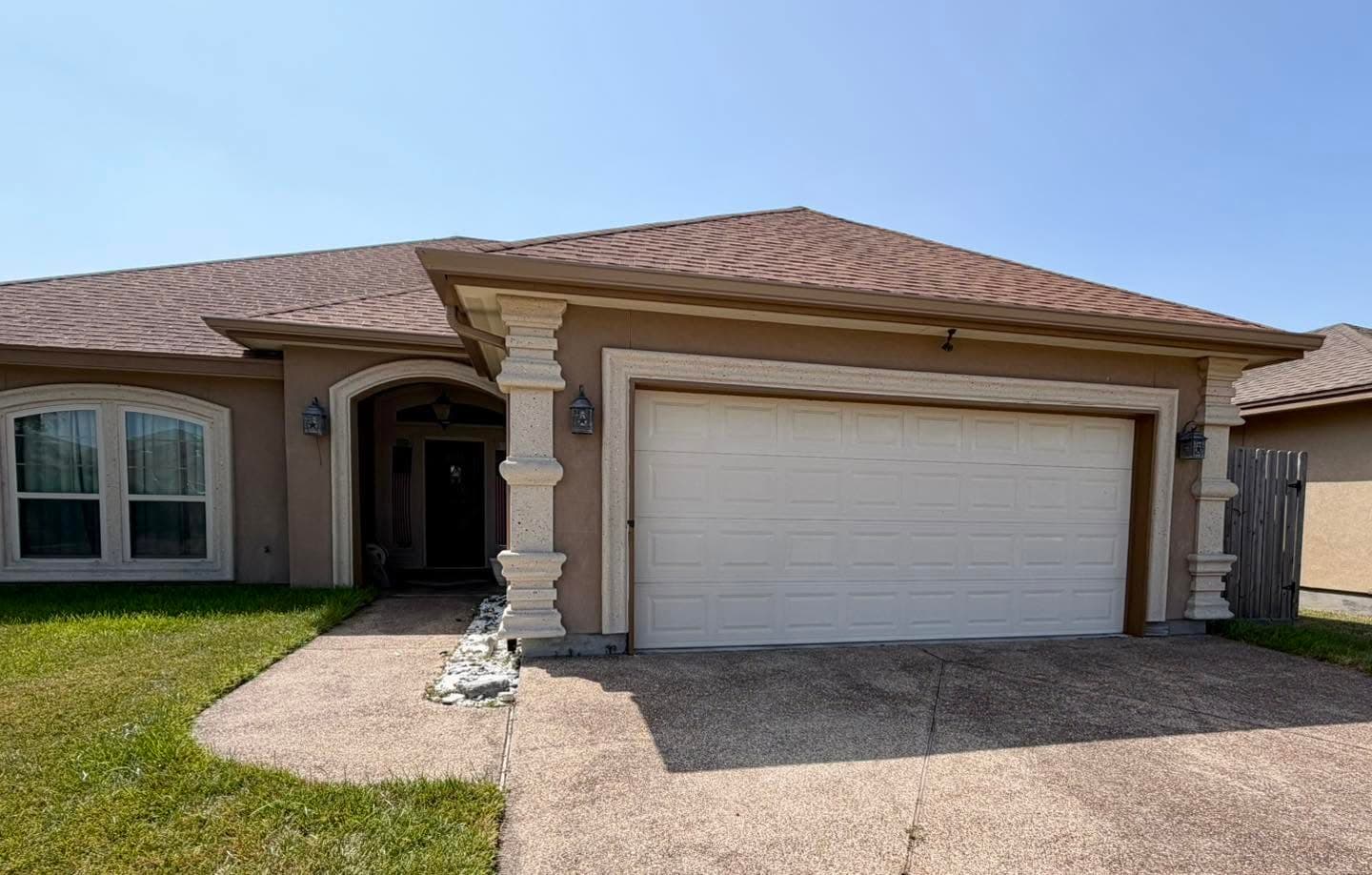 Clean roofline with a seamless gutter and downspout on a Coastal Bend home