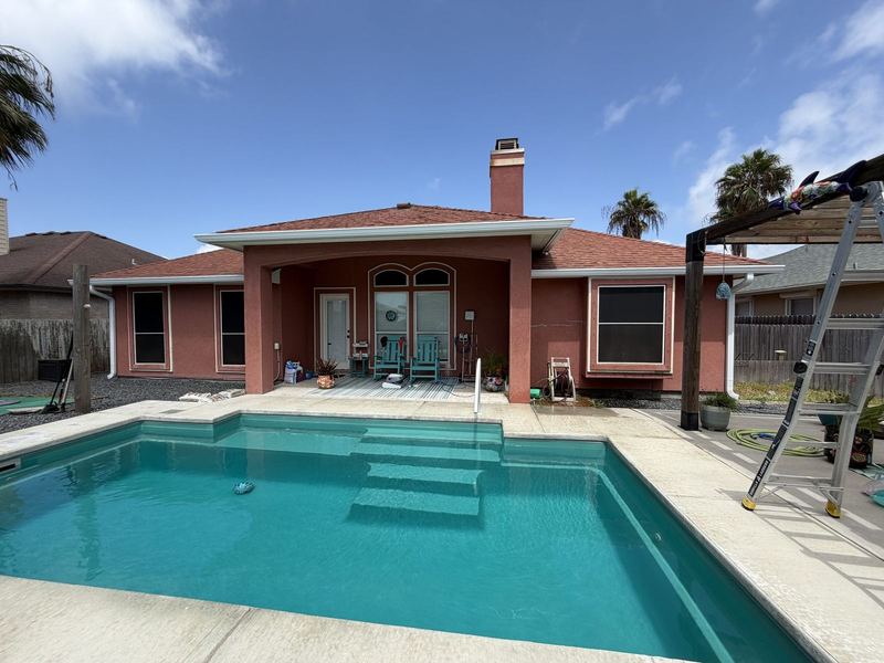 Terracotta stucco house with a pool and seamless gutters in the Corpus Christi area