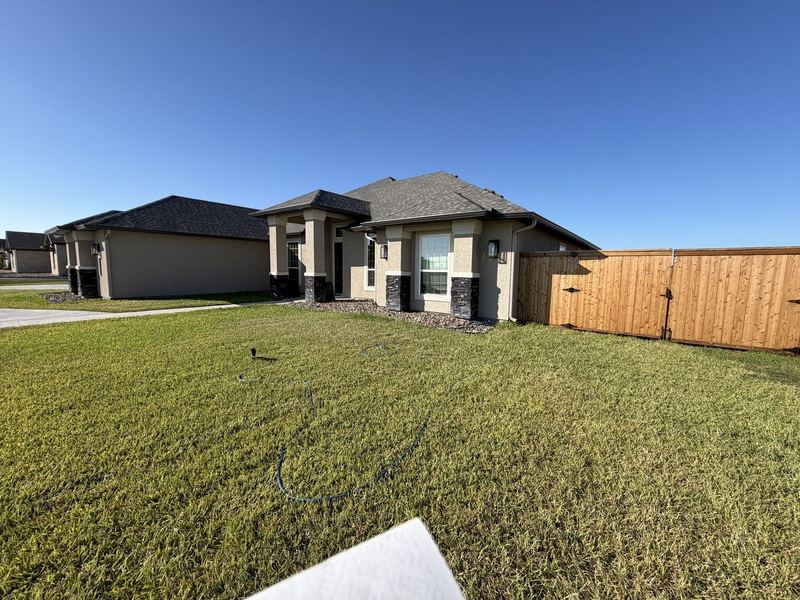 Beige stucco new-build with a continuous seamless gutter run in the Coastal Bend