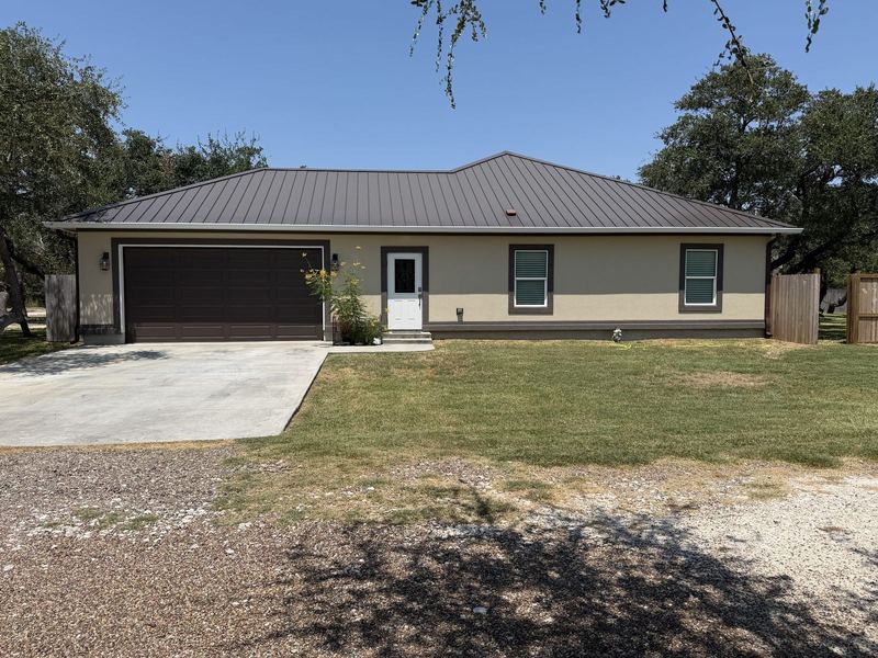 Tan ranch with a metal roof and seamless gutters in the Rockport–Aransas area
