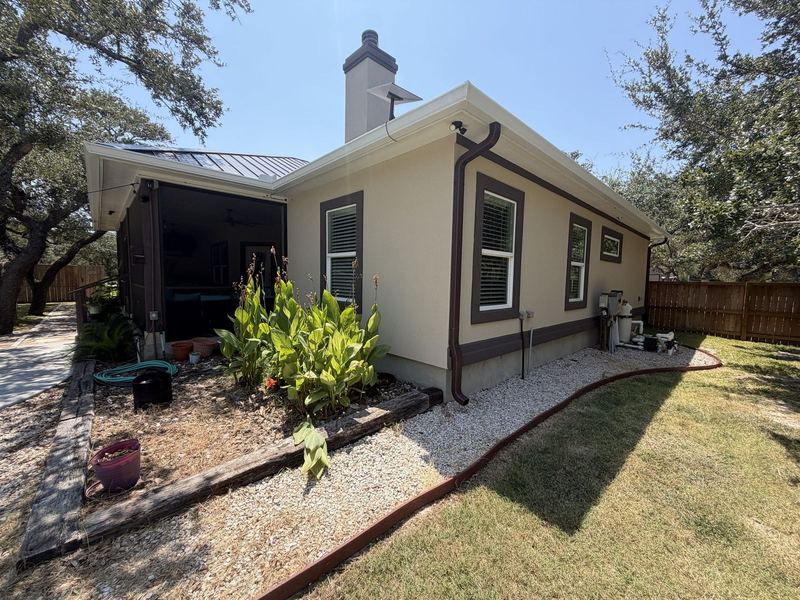 Side eave and downspout on a tan ranch in the Rockport–Aransas area