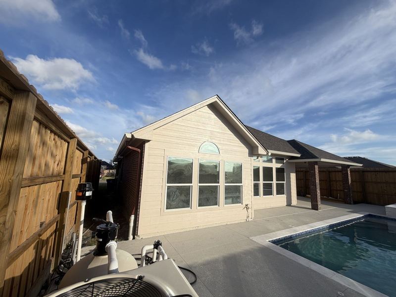 Cream siding and a pool patio with seamless gutters in Portland, TX