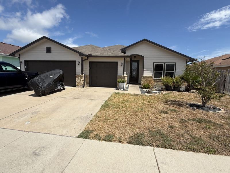 Cream ranch with brown garage doors and seamless gutters in the Corpus Christi area