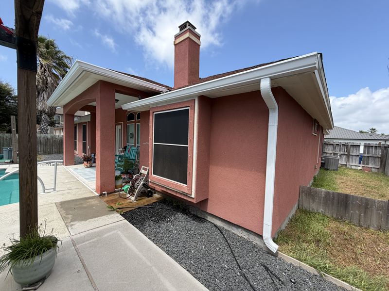 Coral stucco home with pool, white gutters — Corpus Christi, TX