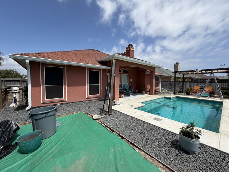 Coral stucco home with pool, white gutters — Corpus Christi, TX