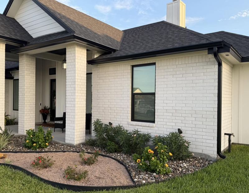 White brick and board-and-batten home, black gutters — Corpus Christi Area, Oct 2026
